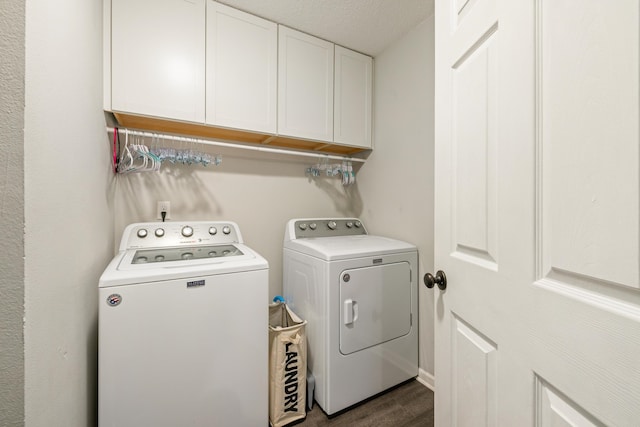 laundry room featuring cabinets, a textured ceiling, separate washer and dryer, and dark hardwood / wood-style flooring