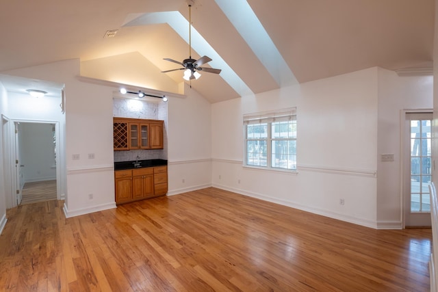 unfurnished living room featuring light hardwood / wood-style floors, vaulted ceiling, and ceiling fan