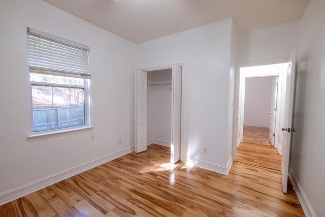 unfurnished bedroom with light wood-type flooring and a closet