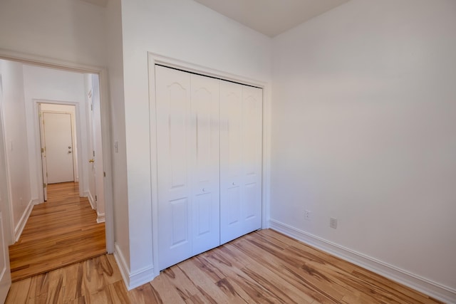 unfurnished bedroom with light hardwood / wood-style floors and a closet