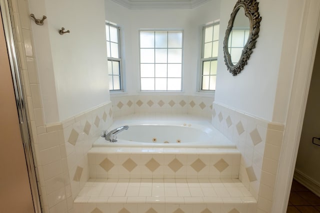 bathroom featuring tile patterned floors, crown molding, and tiled bath