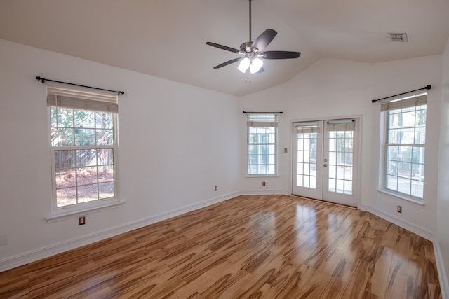 empty room with plenty of natural light, light wood-type flooring, and french doors