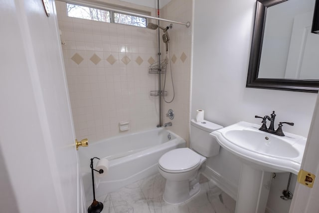 bathroom with tiled shower / bath combo and toilet