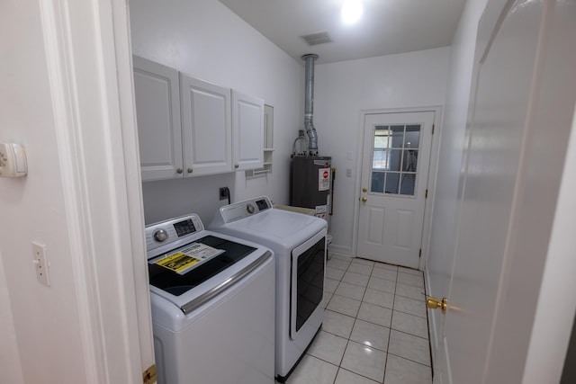 laundry area featuring washing machine and dryer, water heater, light tile patterned floors, and cabinets