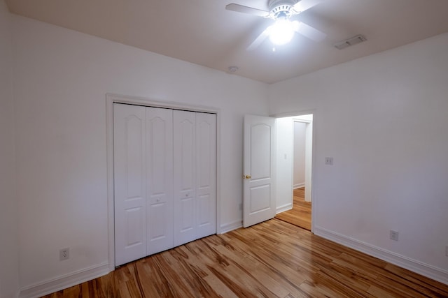 unfurnished bedroom featuring ceiling fan, a closet, and light hardwood / wood-style floors