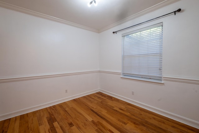 spare room featuring crown molding and hardwood / wood-style floors