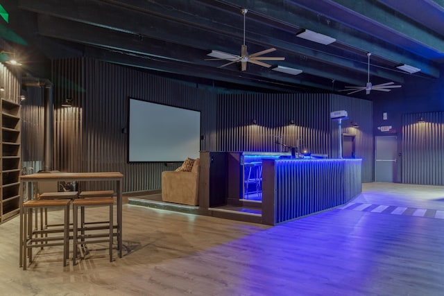 interior space with wood walls, ceiling fan, beam ceiling, a towering ceiling, and wood-type flooring