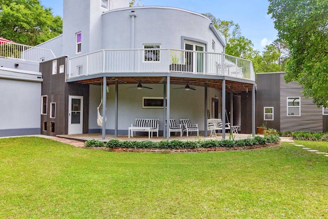 rear view of house featuring a patio area, a lawn, ceiling fan, and a balcony