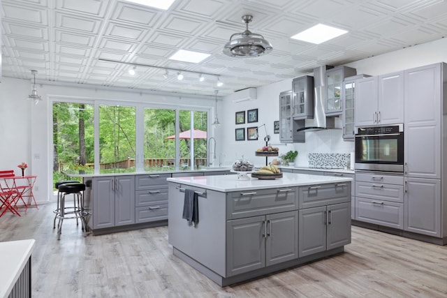 kitchen with gray cabinets, a center island, and stainless steel oven