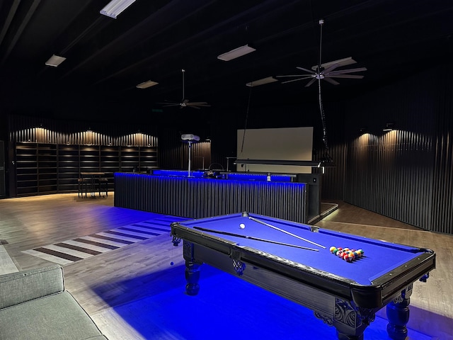 recreation room with hardwood / wood-style floors, a towering ceiling, and pool table