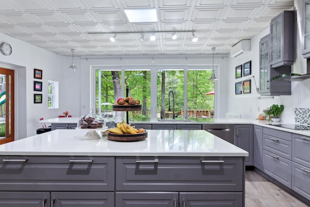 kitchen with gray cabinets, a wealth of natural light, sink, and light hardwood / wood-style flooring