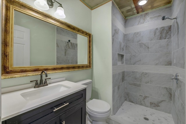 bathroom with vanity, toilet, and tiled shower