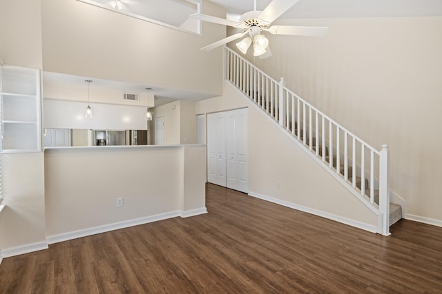 3068 Royal Palm Way, Tallahassee, FL 32309 - unfurnished living room featuring wood finished floors, ceiling fan, a high ceiling, stairway, and baseboards