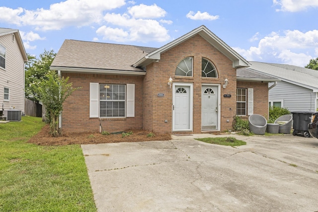 3068 Royal Palm Way, Tallahassee, FL 32309 - view of front of house with brick siding, cooling unit, a shingled roof, and a front yard