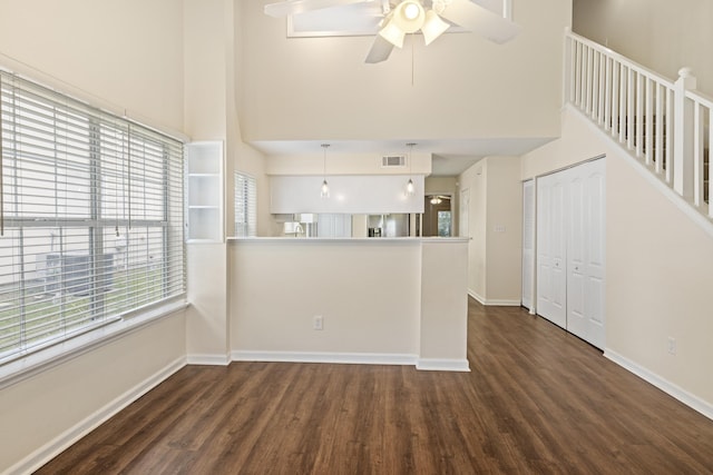 3068 Royal Palm Way, Tallahassee, FL 32309 - unfurnished living room with a towering ceiling, dark wood-type flooring, baseboards, and a ceiling fan