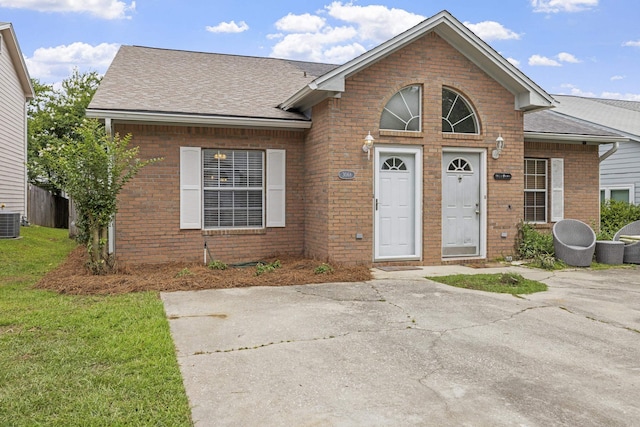 3068 Royal Palm Way, Tallahassee, FL 32309 - view of front of house featuring a shingled roof, brick siding, central air condition unit, and a front lawn