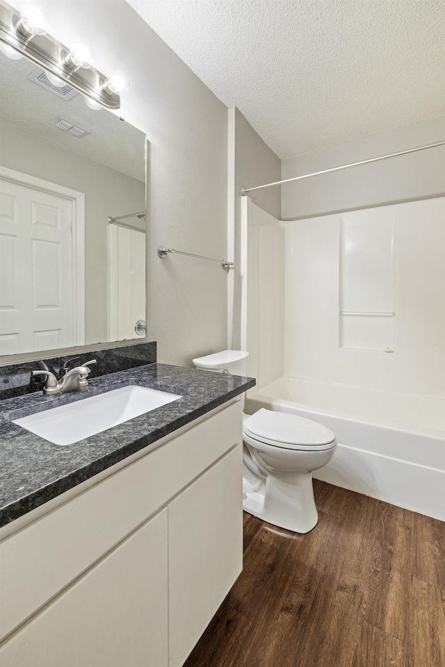3068 Royal Palm Way, Tallahassee, FL 32309 - bathroom featuring wood finished floors, vanity, toilet, bathtub / shower combination, and a textured ceiling