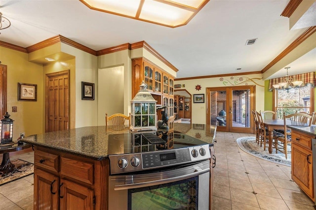 kitchen with french doors, light tile patterned flooring, crown molding, stainless steel range with electric stovetop, and a center island