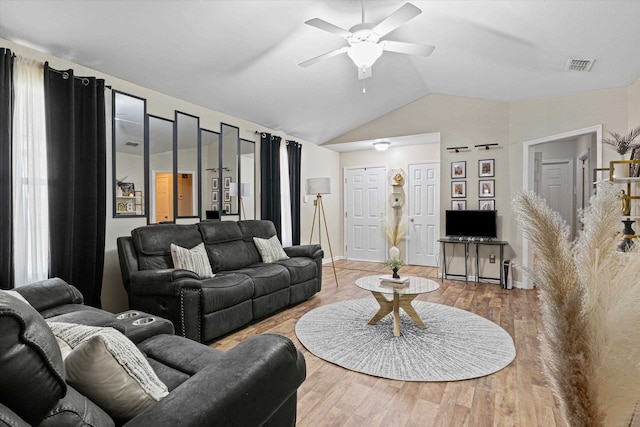 living room with hardwood / wood-style floors, ceiling fan, and vaulted ceiling