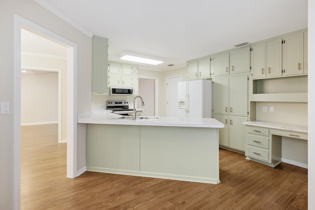 8352 Chickasaw Trl, Tallahassee, FL 32312 - kitchen with white appliances, a sink, wood finished floors, a peninsula, and ornamental molding