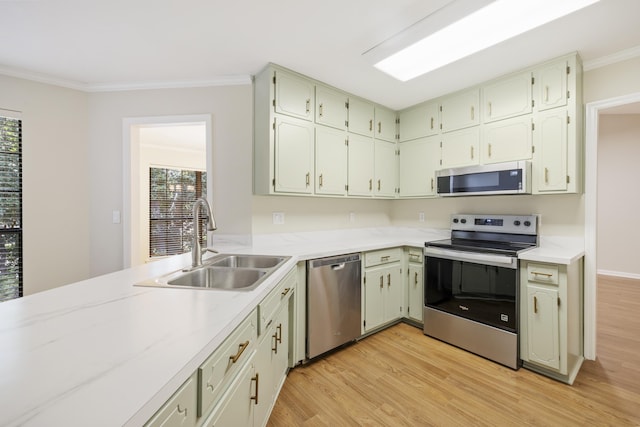8352 Chickasaw Trl, Tallahassee, FL 32312 - kitchen with stainless steel appliances, a sink, light wood-style flooring, crown molding, and light countertops