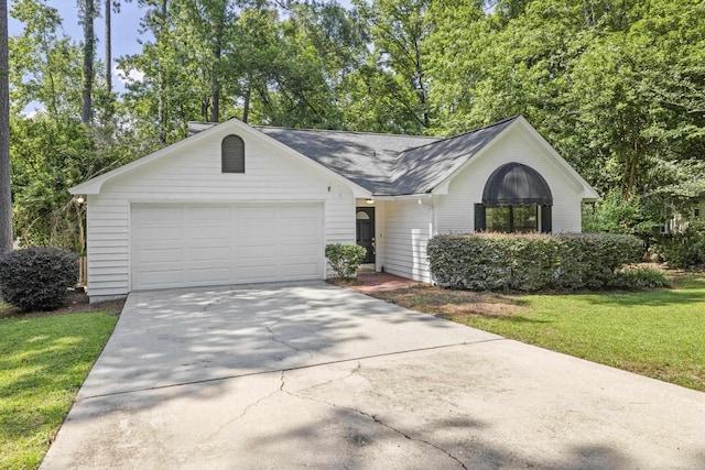 8352 Chickasaw Trl, Tallahassee, FL 32312 - view of front of home with driveway, an attached garage, a front lawn, a shingled roof, and view of wooded area