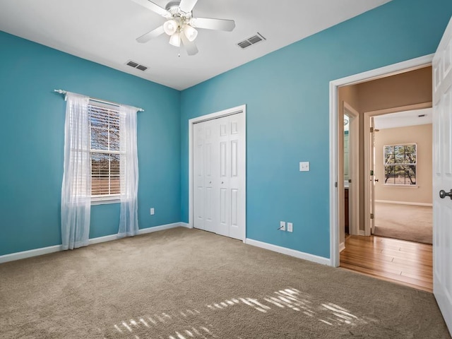 unfurnished bedroom with ceiling fan, carpet, and a closet