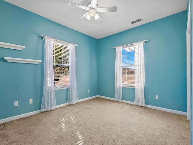 carpeted spare room with ceiling fan