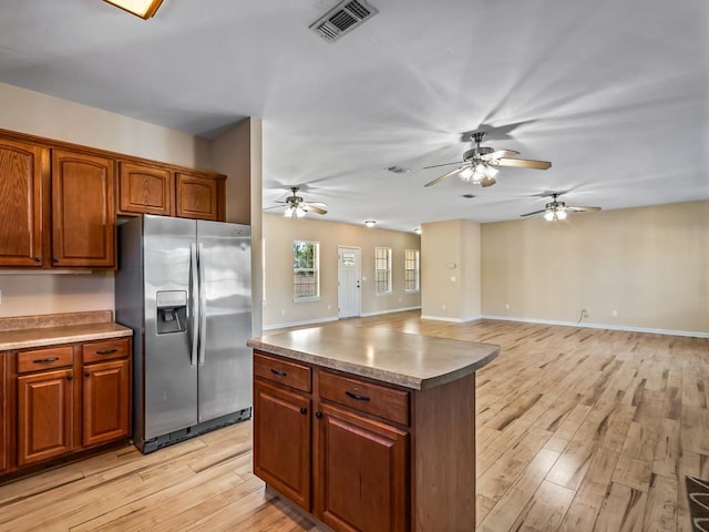 kitchen with light hardwood / wood-style floors, stainless steel fridge, and a center island