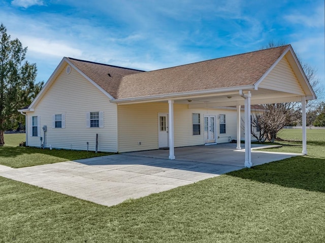 rear view of house with a carport and a yard