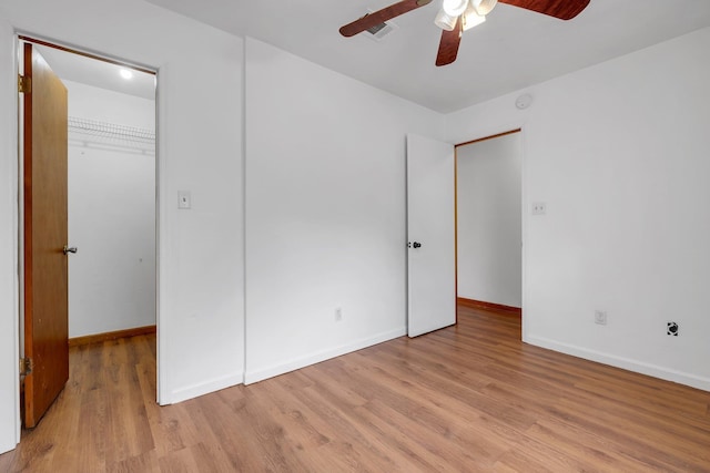 1355 Warrior Way Unit 67, Tallahassee, FL 32304 - unfurnished bedroom featuring a walk in closet, light wood-type flooring, baseboards, and a closet