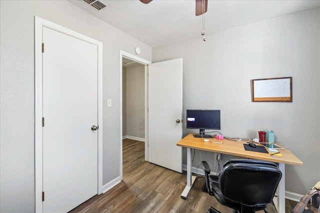 home office with dark hardwood / wood-style flooring and ceiling fan