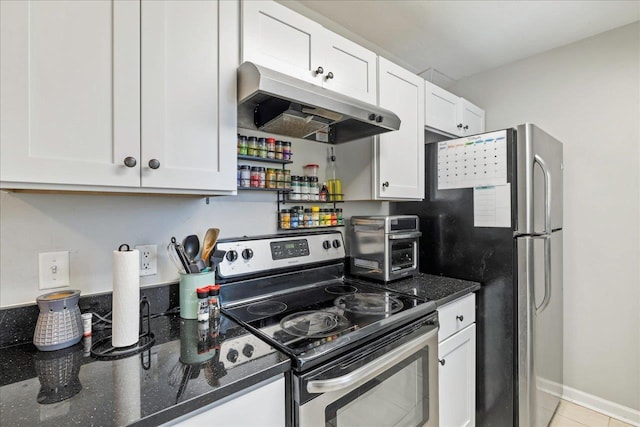 kitchen with light tile patterned floors, dark stone countertops, white cabinetry, and appliances with stainless steel finishes