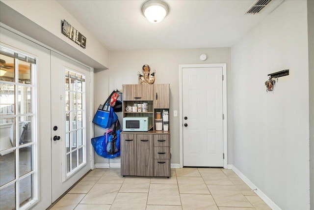 doorway with light tile patterned floors and french doors