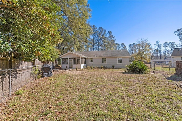 back of house with a lawn and a sunroom