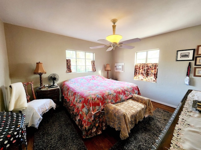 bedroom with ceiling fan, dark hardwood / wood-style floors, a wall unit AC, and multiple windows