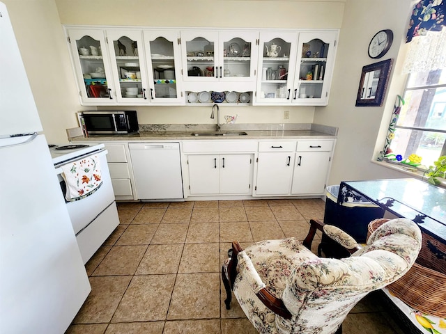 kitchen with sink, light tile patterned floors, white cabinets, and white appliances