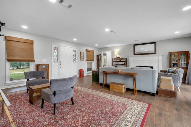 living area with recessed lighting, dark wood-style flooring, visible vents, and a fireplace