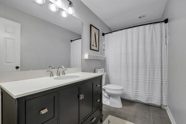 bathroom with tile patterned flooring, baseboards, vanity, and toilet