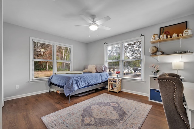 bedroom with dark wood-style floors, ceiling fan, and baseboards