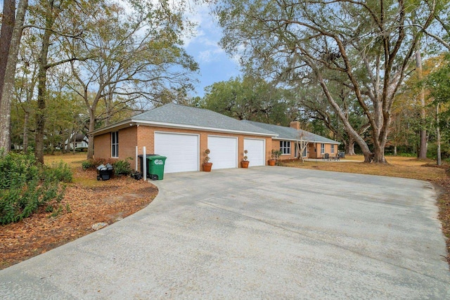 view of home's exterior featuring a garage, brick siding, and driveway