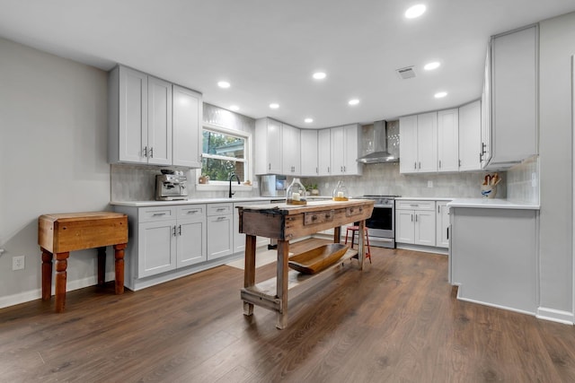 kitchen with visible vents, wall chimney exhaust hood, stainless steel electric range oven, light countertops, and white cabinetry