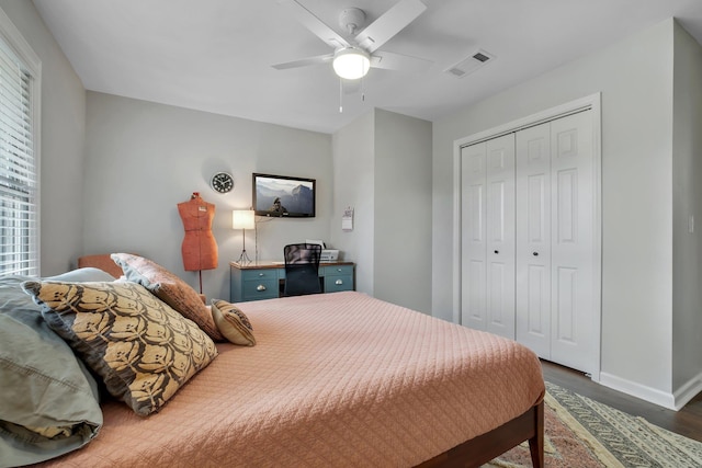 bedroom featuring a ceiling fan, visible vents, baseboards, a closet, and dark wood finished floors