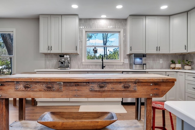 kitchen with tasteful backsplash, light countertops, and a sink