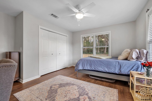 bedroom featuring dark wood-style floors, a closet, visible vents, and baseboards