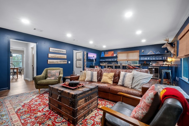 living area with wine cooler, recessed lighting, bar, wood finished floors, and visible vents