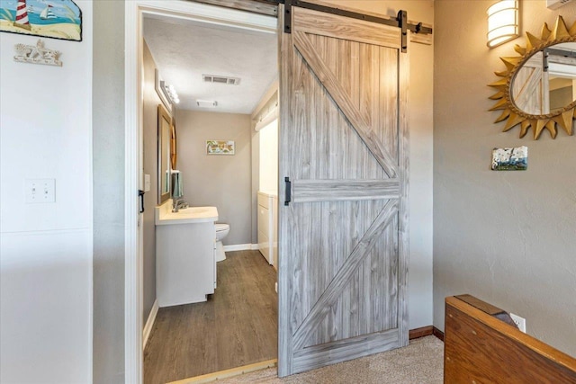 17 Harbour Point Dr, Crawfordville, FL 32327 - corridor featuring a barn door and wood finished floors