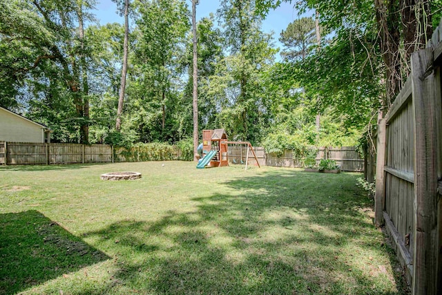 1682 Copperfield Cir, Tallahassee, FL 32312 - fenced backyard featuring a playground and an outdoor fire pit
