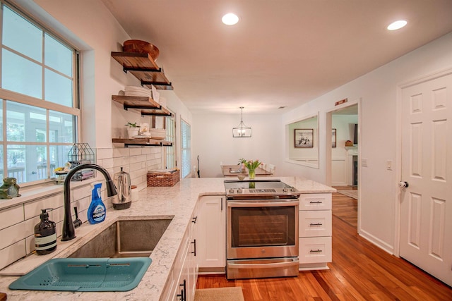 1682 Copperfield Cir, Tallahassee, FL 32312 - kitchen with stainless steel range with electric cooktop, open shelves, white cabinets, light wood-type flooring, and backsplash