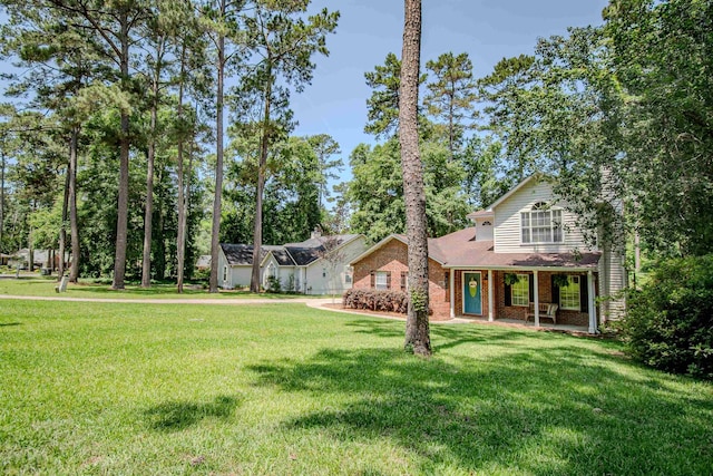 1682 Copperfield Cir, Tallahassee, FL 32312 - view of front facade with brick siding, a front yard, and a porch